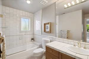 Full bathroom with tile  toilet,  and vanity