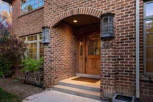 Entrance to property featuring brick siding
