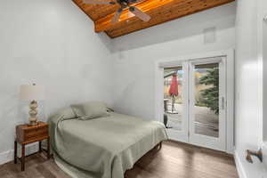 Bedroom featuring wood ceiling, access to outside, high vaulted ceiling, and wood finished floors