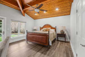 Bedroom with baseboards, multiple windows, lofted ceiling with beams, and wood ceiling
