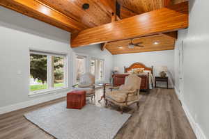 Bedroom with wooden ceiling, baseboards, wood finished floors, and vaulted ceiling with beams