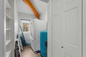 Washroom with light wood finished floors and laundry area