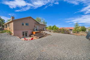 Back of house with a chimney, french doors, stucco siding, central AC unit, and a fenced backyard
