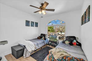 Bedroom featuring baseboards, a ceiling fan, and wood finished floors
