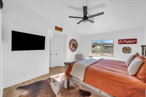 Bedroom featuring vaulted ceiling, ceiling fan, baseboards, and wood finished floors
