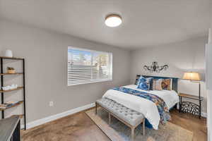 Bedroom featuring baseboards and unfinished concrete flooring