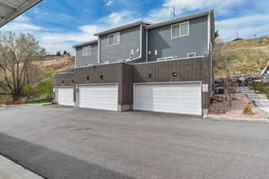 Exterior space with an attached garage, brick siding, and aphalt driveway
