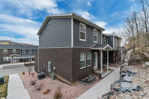 View of property exterior with central AC and brick siding