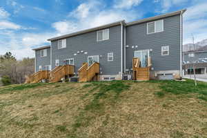 Back of house featuring central AC and a lawn