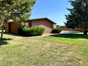 View of property exterior with brick siding and a lawn