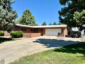 Ranch-style home with concrete driveway, brick siding, and a garage