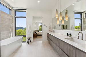 Full bath with a freestanding tub, ensuite bath, recessed lighting, light tile patterned flooring, and a mountain view