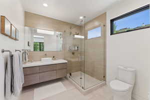 Bathroom with healthy amount of natural light, light tile patterned flooring, a stall shower, and recessed lighting