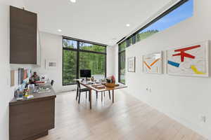 Home office with recessed lighting, light wood-type flooring, and expansive windows