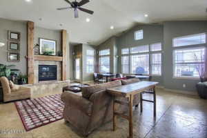 Living room featuring a fireplace, ceiling fan, baseboards, and recessed lighting