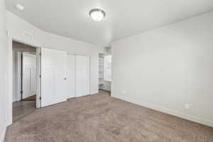 Unfurnished bedroom with baseboards, carpet floors, a closet, and visible vents