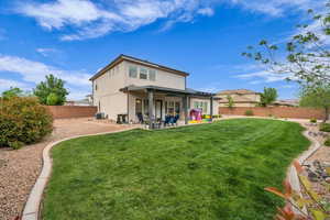 Rear view of house featuring a yard, cooling unit, a patio, stucco siding, and a fenced backyard