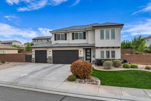 Prairie-style home with fence, an attached garage, driveway, stucco siding, and a front yard