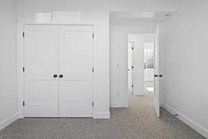 Unfurnished bedroom with carpet flooring, baseboards, and a closet