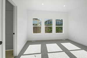 Unfurnished room featuring carpet floors, baseboards, visible vents, and recessed lighting