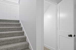 Staircase featuring carpet floors and baseboards