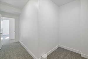 Hallway featuring baseboards and carpet floors