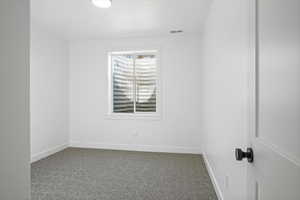 Unfurnished room with baseboards, visible vents, and carpet floors
