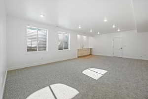 Interior space with recessed lighting, light carpet, baseboards, and a sink