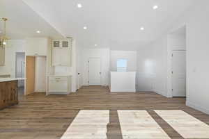 Unfurnished room with baseboards, light wood-style flooring, lofted ceiling, and recessed lighting