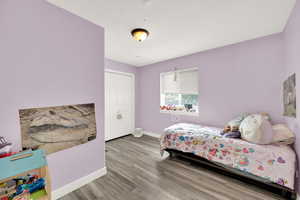 Bedroom with baseboards, a closet, and wood finished floors