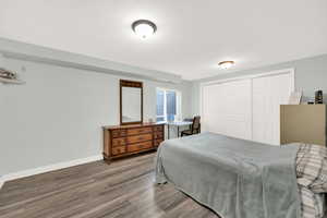 Bedroom with baseboards, a closet, and wood finished floors