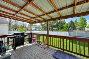 Deck featuring a residential view, a trampoline, area for grilling, a fenced backyard, and a yard
