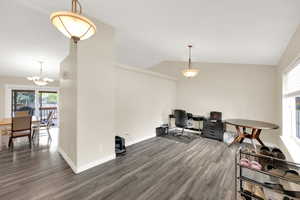 Office area with a wealth of natural light, wood finished floors, lofted ceiling, and a notable chandelier