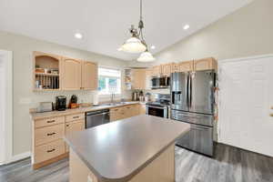 Kitchen featuring open shelves, light brown cabinetry, and appliances with stainless steel finishes