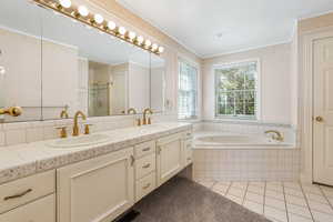 Bathroom featuring a bath, tile patterned flooring, a shower stall, and a sink