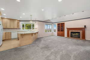 Kitchen with open shelves, tile counters, light colored carpet, and white appliances