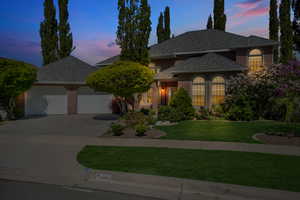 View of front of property featuring a lawn, driveway, brick siding, an attached garage, and a shingled roof