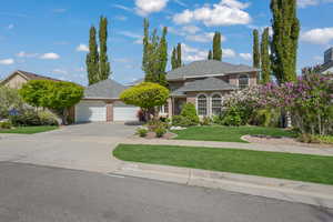 View of front facade featuring an attached garage, brick siding, concrete driveway, a front lawn, and a shingled roof