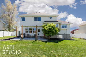 Rear view of house featuring a yard, a patio, and a fenced backyard