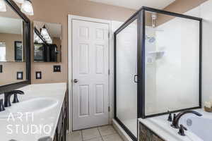 Bathroom featuring a shower stall, tile patterned flooring, vanity, and a bath