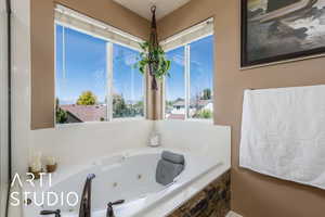 Full bathroom with a healthy amount of sunlight and a whirlpool tub