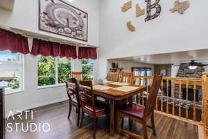 Dining space with a towering ceiling, visible vents, ceiling fan, dark wood-style floors, and baseboards