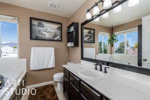 Bathroom with toilet, vanity, visible vents, tile patterned flooring, and baseboards