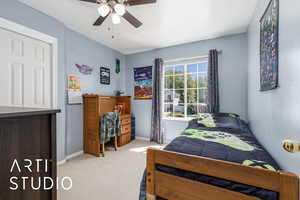 Carpeted bedroom featuring baseboards and a ceiling fan