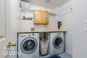 Laundry area with baseboards, independent washer and dryer, visible vents, and cabinet space
