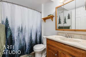 Bathroom featuring vanity, toilet, a shower with curtain, and visible vents