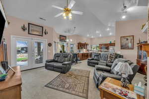 Living room with french doors, a ceiling fan, visible vents, light carpet, and lofted ceiling