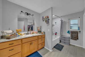 Bathroom with baseboards,  shower combination, and vanity