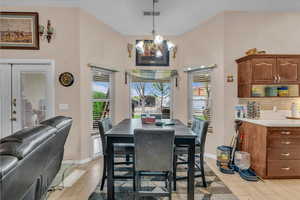 Dining space featuring baseboards, light wood finished floors, an inviting chandelier, and visible vents