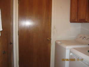 Laundry area featuring washer and dryer and cabinet space